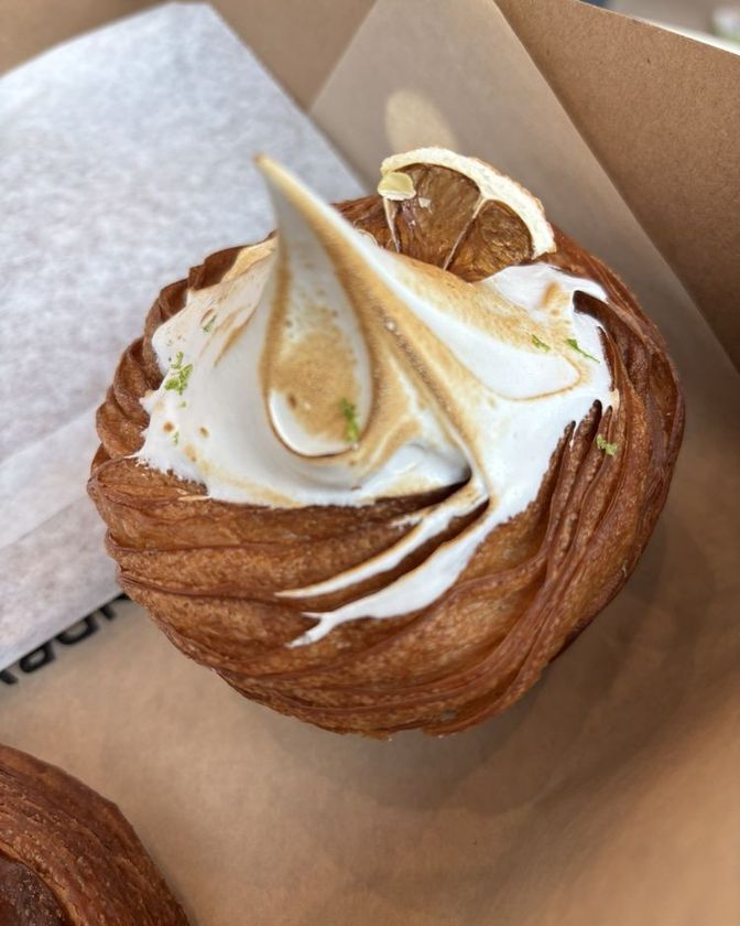 Yuzu meringue croiffin topped with a torched meringue swirl and a dried citrus slice